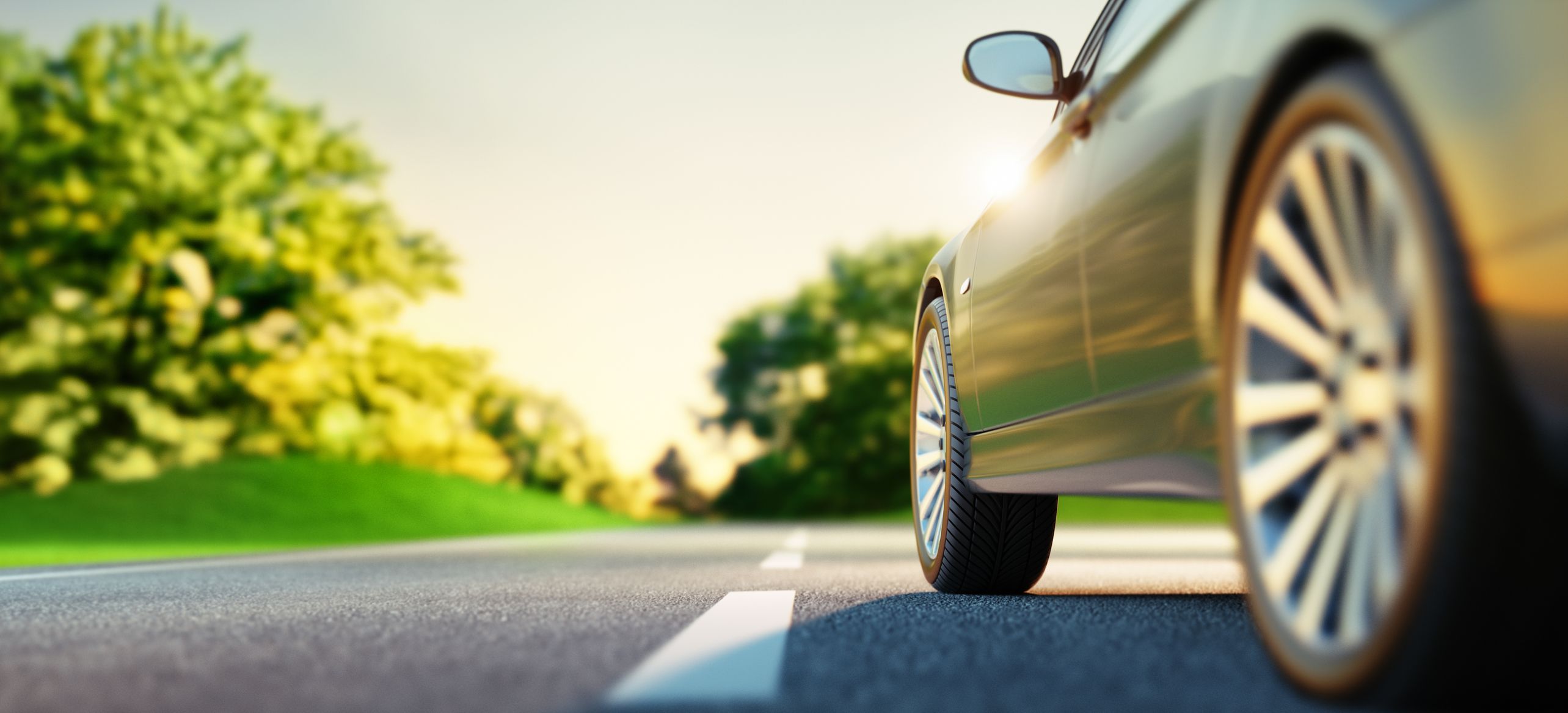 From the wheels upward, a car on a sunny road 