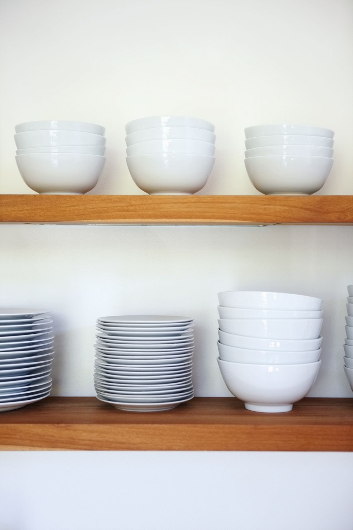 White dishes stacked on kitchen shelves