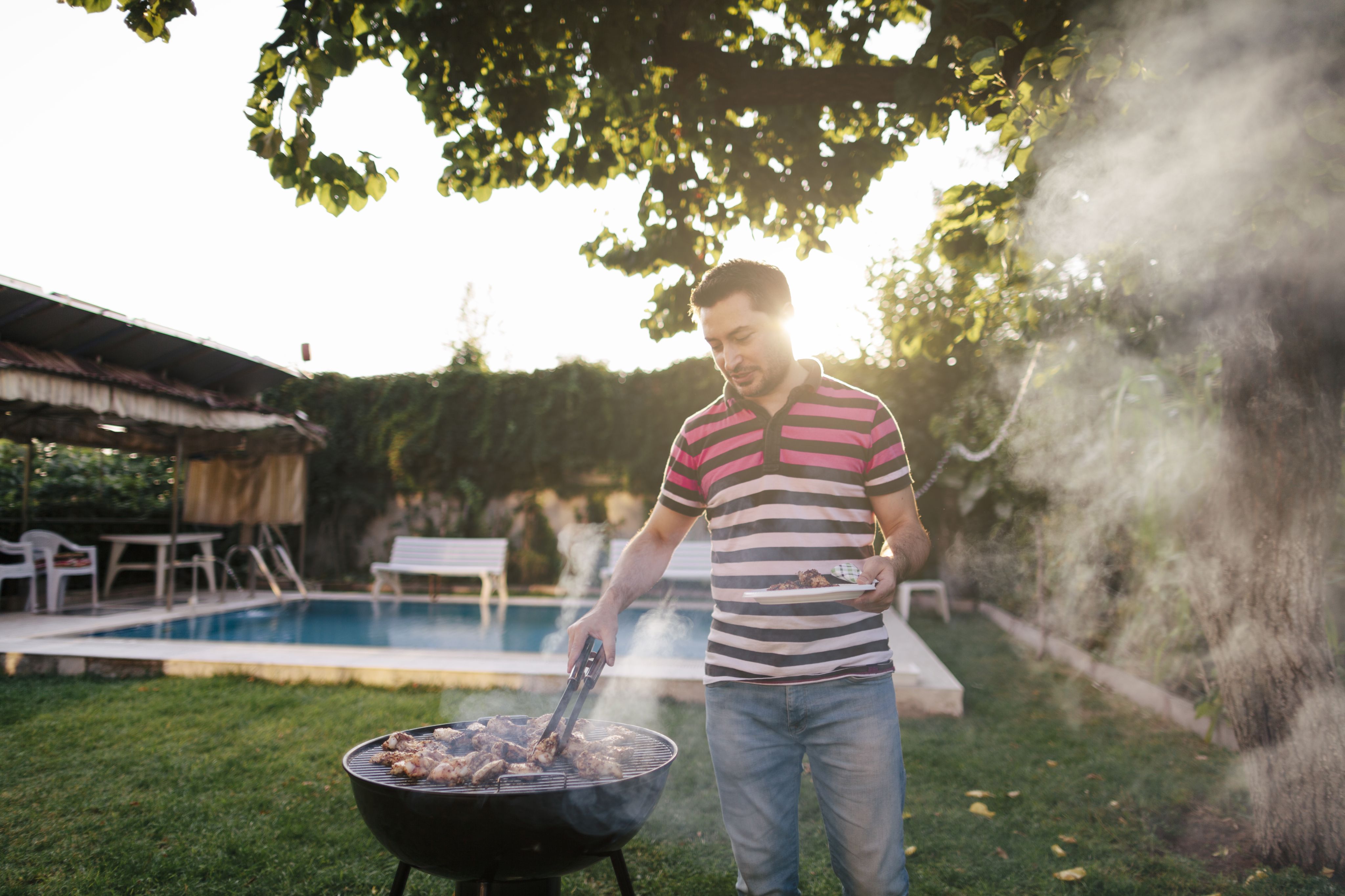 Man grilling outdoors on a charcoal grill