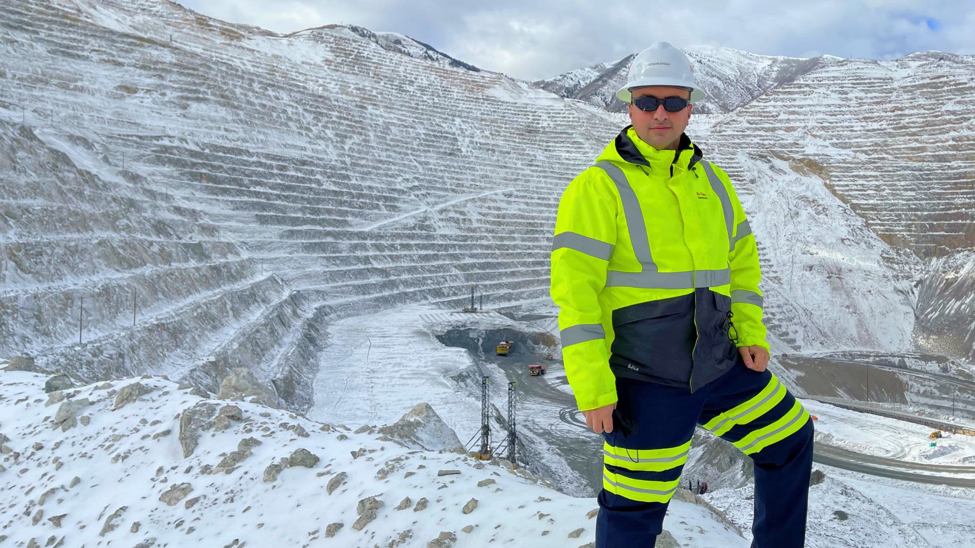 Man in yellow hi-visibility mining uniform standing at the edge of the Kennecott Copper Mine in Utah, USA
