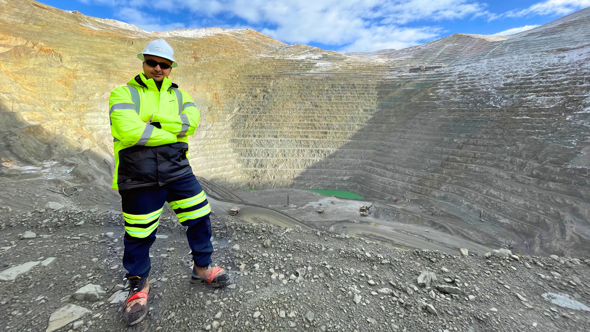 Man in yellow hi-visibility mining uniform standing at the edge of the Kennecott Copper Mine in Utah, USA
